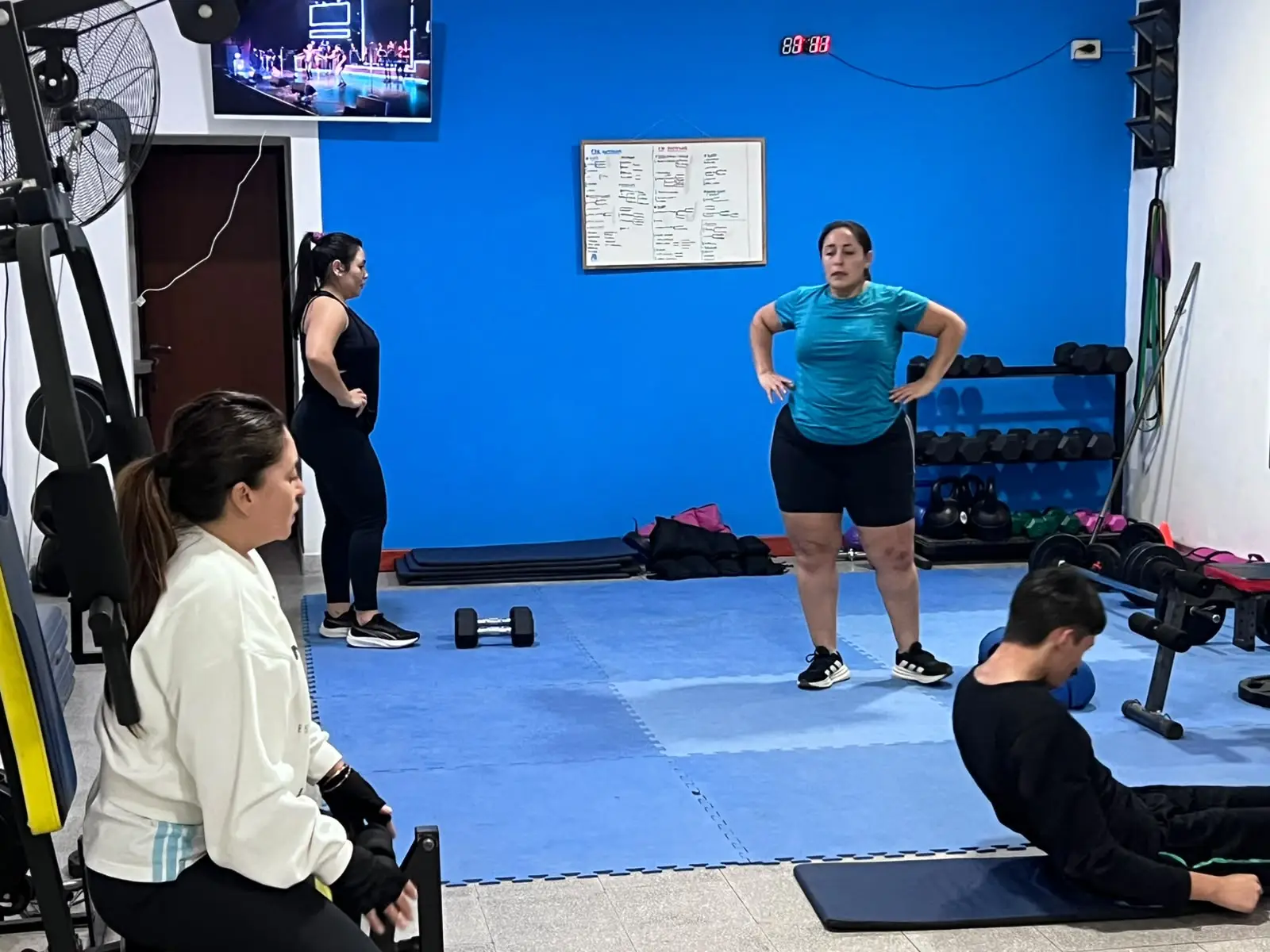 Grupo entrenando con el profe acompañando en el salón